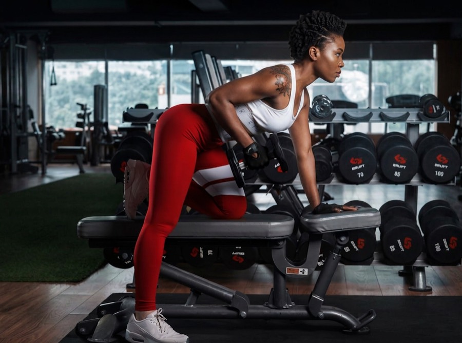 A woman working through a set on a weight bench